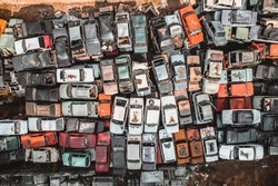 Aerial view of a Soviet automobile dump from a drone. Shooting from above at heaps of rusty cars. Abandoned Russian cars awaiting disposal and recycling