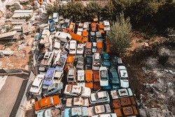 Aerial view of a Soviet automobile dump from a drone. Shooting from above at heaps of rusty cars. Abandoned Russian cars awaiting disposal and recycling