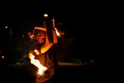 Fire show. The fakir juggles Poi. Night performance. Dramatic portrait. Heat and danger.