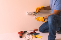 hand man glove hold outlet and connectors conduit on wall, electrician maintenance installation, contractors, craftsman, handyman, plug,  wiring,