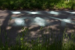 Sun glare on the pavement. Sun glare on the road. Bright glare from glass . Light on the road.