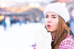 freezing woman, a young beautiful frozen girl in the snow suffers from cold icy weather, shakes, trembles outside on an icy snowy day, low temperature, breathes with her hands, tries to keep warm