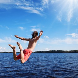 Young man jumping into water 