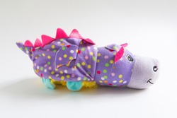 Plush soft children's toy purple dragon with colorful round spots. Turn it inside out. White background, space for text