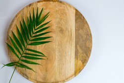 Palm leaf on wooden tray on white background. Place for text. Blank white business card mockups on wooden plate. Wooden backgound with palm leaf. Modern template. Flat lay, top 