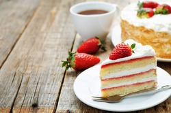 cake with cream and strawberries on a dark wood background. tinting. selective focus