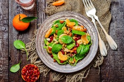 Spinach tangerines pomegranate avocado almonds walnuts salad. toning. selective focus