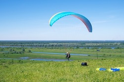 The sportsman flying on a paraglider. 
Paragliding take off. Travel destination. Summer and holiday concept. 