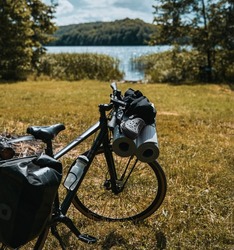 The bicycle is packed with many bags and other equipment ready for adventure and travel. Tourism on a mountain bike. Bike packing adventures in the woods and on the lakes. Baggage rack on the bike.