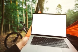 Modern laptop mockup. Working remotely in the forest with a bicycle in the background