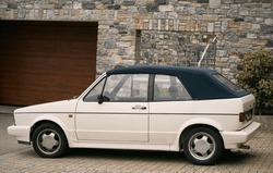White Retro Cabriolet, an Iconic 80s European Convertible, Graces the Open Road. Retro cabriolet. Convertible vehicle. White 80s European compact convertible hatchback car. Timeless Elegance