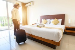 Portrait of tourist woman with her luggage after check-in hotel bedroom. Conceptual of travel and vacations.