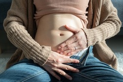 Cropped shot of first month pregnant woman hugging her stomach. The first month of pregnancy begins in the third week after your last menstrual period.