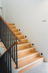 Modern wooden staircase with railing handle for safety.