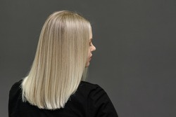 Blonde model with straight hair, look from behind. Hair bleaching result. Space for text