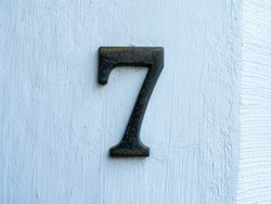 number seven on a white concrete wall for the indication of house number