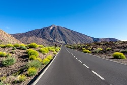Scenic mountain road leading to volcano Pico del Teide, Mount El Teide National Park, Tenerife, Canary Islands, Spain, Europe. Volcanic dry landscape. Road trip on a sunny summer day. Freedom vibes