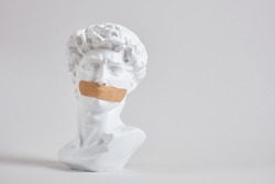 bust of an antique king with a medical adhesive plaster on his face, silence and ignoring the problem concept, a man with a sealed mouth