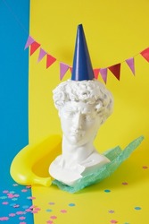1 april date. April Fool's Day. creative minimal concept. creative concept for april's day with a replica of the bust of david in a banquet hat and a fake banana