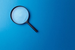 Concept information search. Magnifying glass on classic blue background. Top view. Flat lay. Copy space. Minimal creative concept. Trendy color. Searching information data on internet