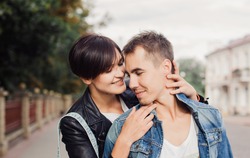 Young couple in love,romantic outdoor fashion portrait of elegant couple in love hugs and posing at the city urban street, stylish clothes, vacation, family, lovers.sensual young woman kissing her man