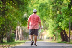 Fat man exercising By walking to burn fat And run slowly to exercise in the park