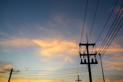 silhouette of electric poles and electric wires in the evening sunset high voltage poles in the beautiful orange and blue sky