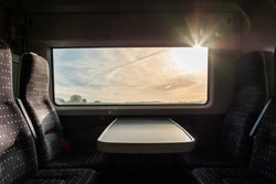 View from inside a english high speed train, travel to destination with noone on board. Trains empty during uk pandemic lockdown. View of the harsh morning sun outside the window