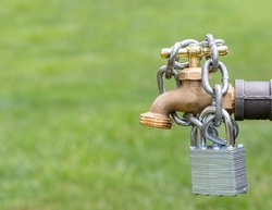 Outdoor water faucet with lock and chain. Water restriction, supply and shortage concept