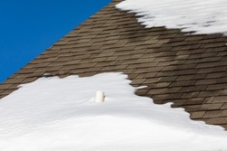 Plumbing vent pipe on roof with snow. Plumbing drain problem, home maintenance and repair concept.