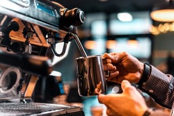 Barista pouring milk for prepare cup of coffee. Latte art. Morning cup of coffee in café. Brewing coffee. Coffee shop concept. Vertical photo