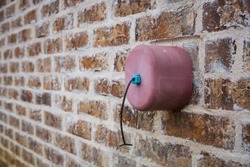 Faucet cover on exterior brick wall