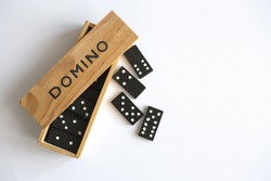 Domino game in wooden box on white background, top view. Table game
