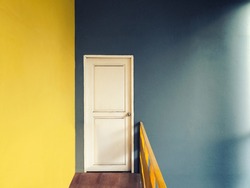 Vintage style with grain filter of empty hallway to small room of white door with yellow and green blue wall and wooden floor lighted with sun light from window on right side, warm colour tone