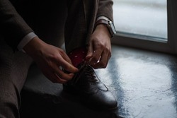 man tying long laces on his shoes