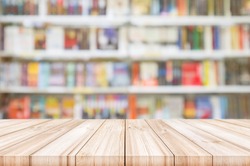 Empty wooden table top with Blur bookshelves in bookstore background. can be used product display. 