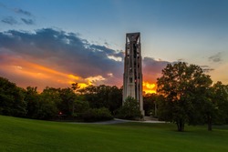 Sunbeams bursting through clouds at sunset behind the Carillon bell tower in Naperville, Illlinois just west of Chicago