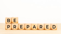 Be prepared phrase in wooden blocks on table. White background. Copy space