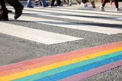 Rainbow flag, gay pride flag or LGBTQ pride flag painted on asphalt. City crosswalk decoration