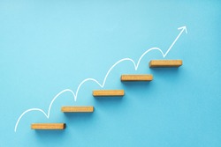 Rising arrow on staircase on blue background. Growth, increasing business, success process concept. Copy space