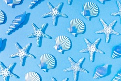 Blue summer background of a pattern of decorative glass sea conch. Starfish, sea conch, scallop