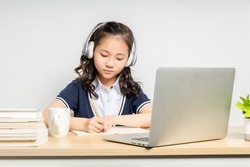 Asian primary school girls taking online classes

