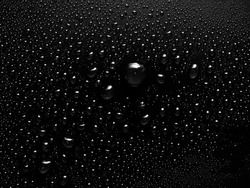 a close-up image of small water drops on a black background. Smooth background with water drops. Macro photography