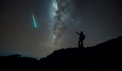 Trekker with milky way and shooting star in background, Annapurna region, Nepal