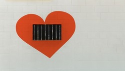 White wall with red heart shape and bars on the window, lock your heart and Free your mind concept