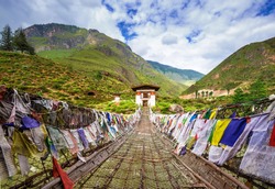 Walking suspension bridge with colorful prayer flags in Bhutan
