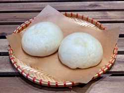 Bánh bao is a Vietnamese steamed bun with meat filling based on the Cantonese dim sum called Dai Bao. Traditional asian street food on wooden table in Vietnam is great for menu, food hall decorations.