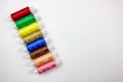 The Colored threads on a white background. Spools of thread for sewing. Thread selection.The Sewing threads.Colored threads on a white background. Spools of thread for sewing. Thread selection.