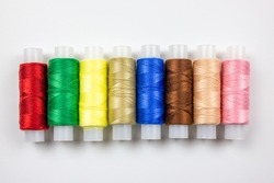 The Colored threads on a white background. Spools of thread for sewing. Thread selection.The Sewing threads.Colored threads on a white background. Spools of thread for sewing. Thread selection.