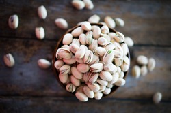Close-up Of Roasted Pistachios On Wooden Background